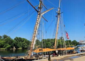 Three tall ships along a dock.