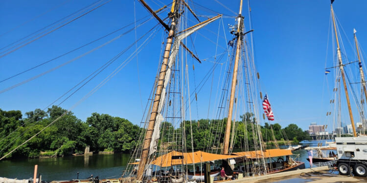 Three tall ships along a dock.