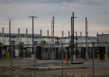 An outside view of a data center in Hilliard, Ohio behind a fence.