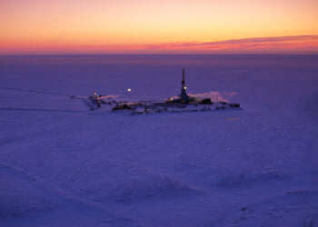 An oil well at Alaska's Prudhoe Bay as the sun sets.
