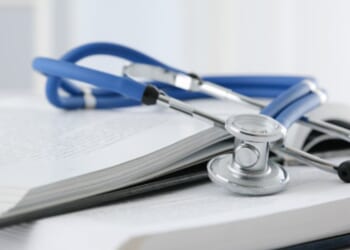 A stethoscope sits on a stack of books.