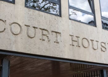 The lettering of a court house is shown on the concrete wall of a courthouse.