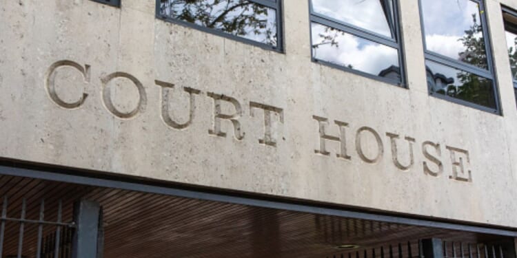 The lettering of a court house is shown on the concrete wall of a courthouse.