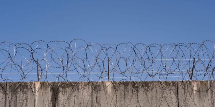 A prison wall with barbed wire in Frankfurt, Germany.