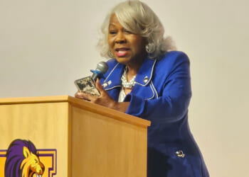 Virginia President Pro Tempore L. Louise Lucas speaks at a tan podium.