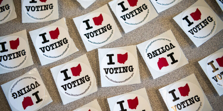 A table full of stickers to hand out to voters is shown.