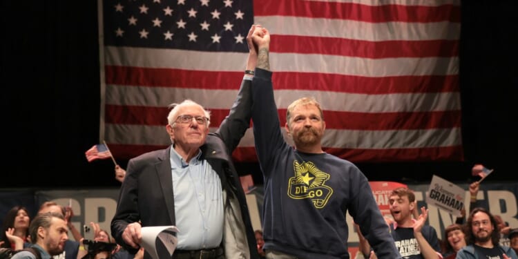 Sen. Bernie Sanders and Democratic U.S. Senate candidate Graham Platner stand together during a “Fighting Oligarchy” tour stop at the Collins Center for the Arts on the University of Maine campus on May 24, 2026, in Orono, Maine.