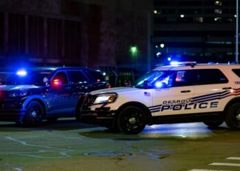 Two Detroit police vehicles flash their lights in the street on Dec. 20, 2020.