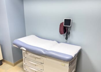 An empty examination table in a doctor’s office.