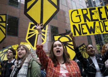 Protesters holding "green new deal" signs