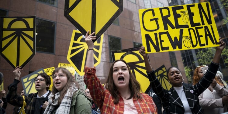 Protesters holding "green new deal" signs