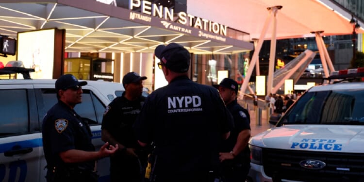 New York City police officers gather outside Penn Station on Sunday after a stabbling that left five wounded.