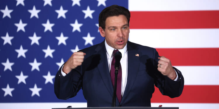 Ron DeSantis speaks in front of an American flag