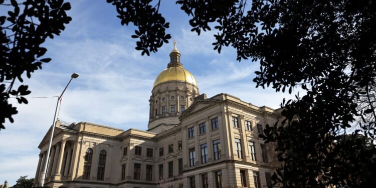 The Georgia State Capitol Building is shown among trees.