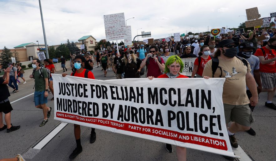 Demonstrators carry a banner while marching down Interstate 225 during a rally and march over the death of Elijah McClain, June 27, 2020, in Aurora, Colo. A trial for two of the officers charged for McClain's death is set to begin Friday, Sept. 15, 2023 with jury selection. (AP Photo/David Zalubowski, file)
