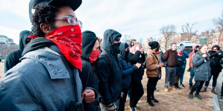 Antifa members form a circle and surround helmeted members of a right wing and pro-Trump group during the 2019 Women's March at Boston Common in Boston, Massachusetts, on Jan. 19, 2019.