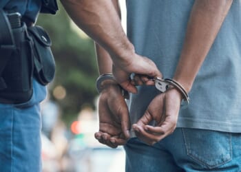 A police officer handcuffs a suspect.
