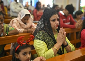 Christians kneel in the pews of a church and pray in Bengaluru on Dec. 25, 2025.