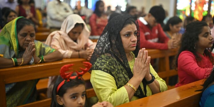 Christians kneel in the pews of a church and pray in Bengaluru on Dec. 25, 2025.