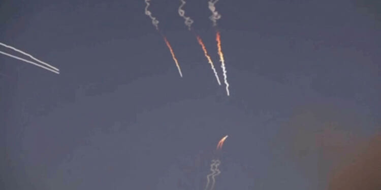 Iranian missiles streak against a dark sky.