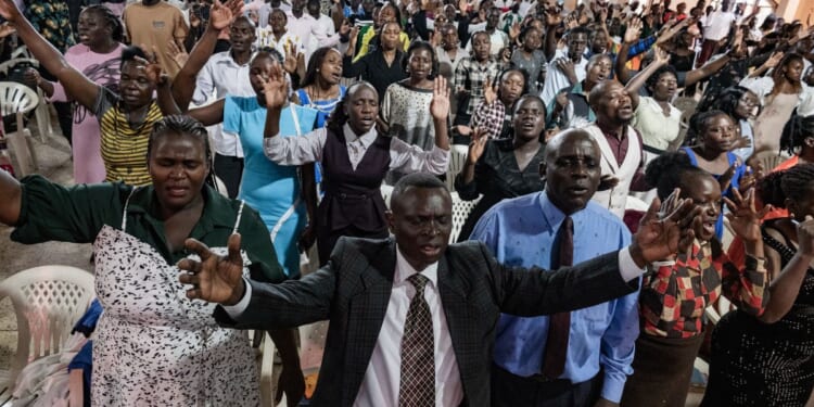 Christians worship and raise their hands at Victory church in Kampala, Uganda, on Jan. 11, 2026.