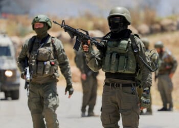 Israeli soldiers walk near a roadside fence in the occupied West Bank on June 5, 2026.