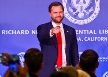 JD Vance in blue jacket and red tie points into the audience with a smile at the Richard Nixon Presidential Library.