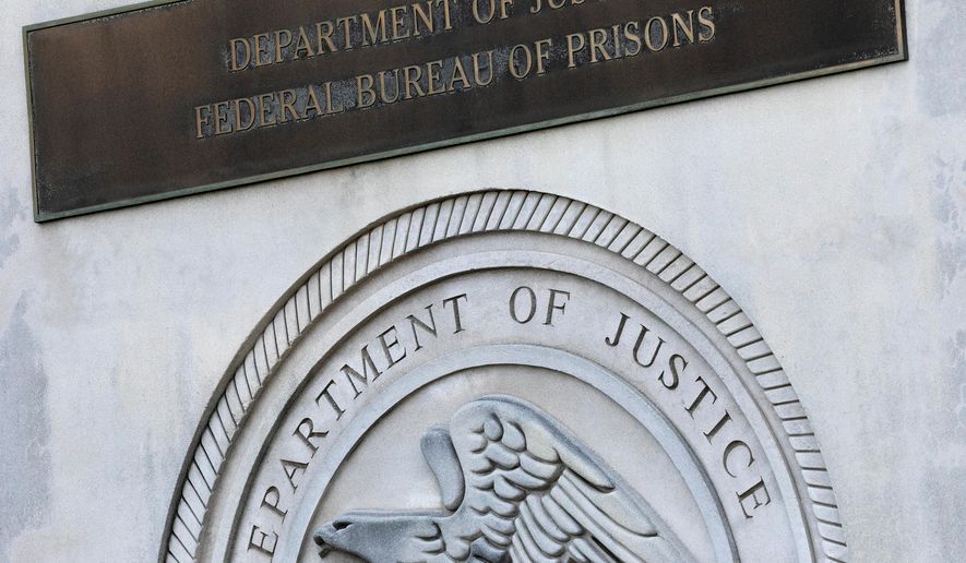 FILE - A sign for the Department of Justice Federal Bureau of Prisons is displayed at the Metropolitan Detention Center in the Brooklyn borough of New York on July 6, 2020. (AP Photo/Mark Lennihan, File)