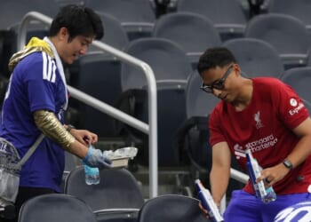 Japan fans clear trash in the stands Sunday after the FIFA World Cup 2026 Group F match between Netherlands and Japan at Dallas Stadium in Arlington, Texas.