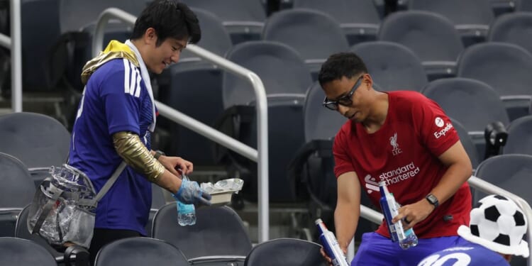 Japan fans clear trash in the stands Sunday after the FIFA World Cup 2026 Group F match between Netherlands and Japan at Dallas Stadium in Arlington, Texas.