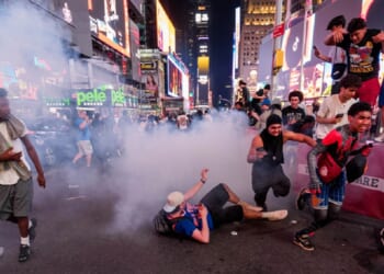 New York Knicks fans run from fireworks in Times Square during Game 4 of the NBA Finals between New York Knicks and San Antonio Spurs, on Tuesday in New York City.