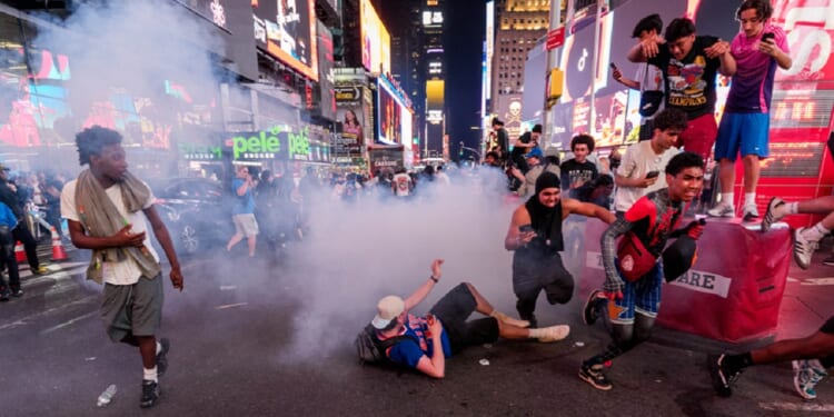 New York Knicks fans run from fireworks in Times Square during Game 4 of the NBA Finals between New York Knicks and San Antonio Spurs, on Tuesday in New York City.