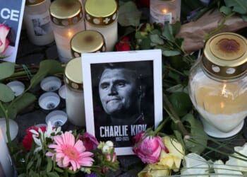 Flowers and candles are seen at a makeshift memorial for murdered American conservative activist Charlie Kirk outside the U.S. embassy as its flag hangs at half-staff on Sept. 14, 2025, in Berlin, Germany.