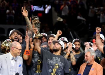 Jalen Brunson of the New York Knicks lifts the Bill Russell NBA Finals Most Valuable Player Award trophy after defeating the San Antonio Spurs in Game Five of the 2026 NBA Finals at Frost Bank Center on June 13, 2026, in San Antonio, Texas.