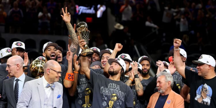 Jalen Brunson of the New York Knicks lifts the Bill Russell NBA Finals Most Valuable Player Award trophy after defeating the San Antonio Spurs in Game Five of the 2026 NBA Finals at Frost Bank Center on June 13, 2026, in San Antonio, Texas.