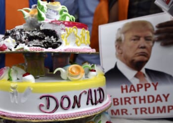Supporters stand with a birthday cake to celebrate President Trump's birthday.