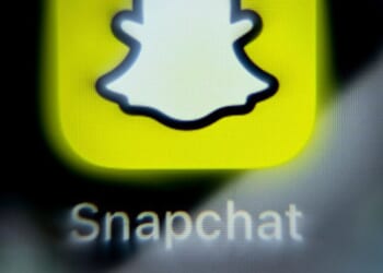 The Snapchat logo is displayed on a phone screen.