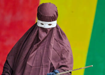 A member of Aceh's Sharia police wields a rattan stick during a public flogging.