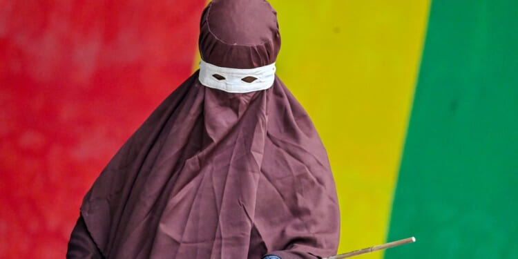 A member of Aceh's Sharia police wields a rattan stick during a public flogging.