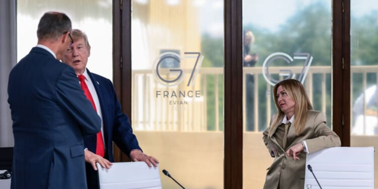 President Donald Trump speaks with German Chancellor Friedrich Merz next to Italian Prime Minister Giorgia Meloni at a working lunch with leaders of G7 and the Middle East, on June 16, 2026, in Evian-les-Bains, France.