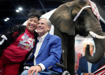 Aida Scott takes a photo with Governor Greg Abbott in front of an elephant named, Paige.
