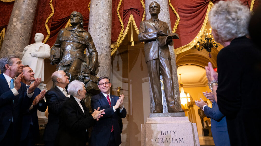 Speaker of the House Mike Johnson (C)(R-LA) and others help unveil a statue of the late US Southern Baptist Minister, Billy Graham, in Statuary Hall at the US Capitol in Washington, DC, on May 16, 2024. Graham was the most widely heard Christian evangelist in history, preaching in person to more than 210 million people worldwide. (Photo by ROBERTO SCHMIDT / AFP) (Photo by ROBERTO SCHMIDT/AFP via Getty Images)