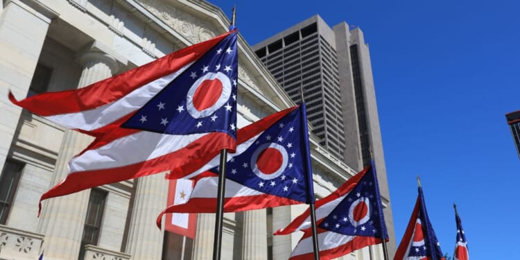 State of Ohio flags waving in front of the State House in Columbus, Ohio.