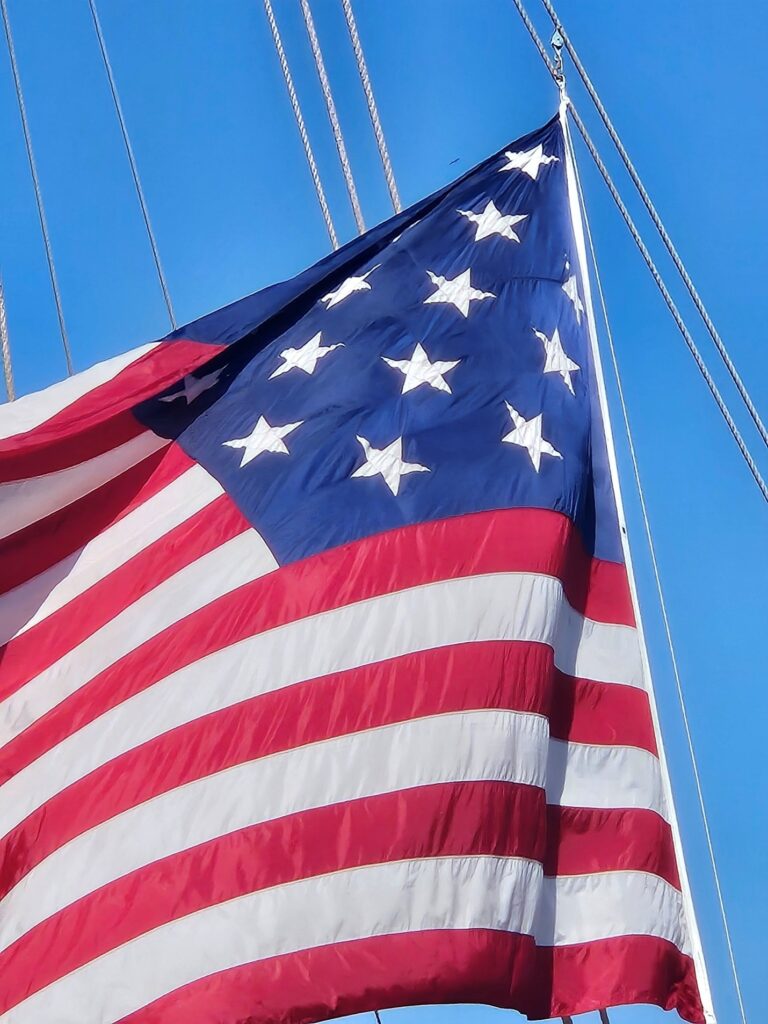 Low angle shot of an American flag with 15-stars against a blue sky.