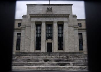 Dark clouds fill the sky behind the Federal Reserve Headquarters photographed from a fence on June 17, 2020.