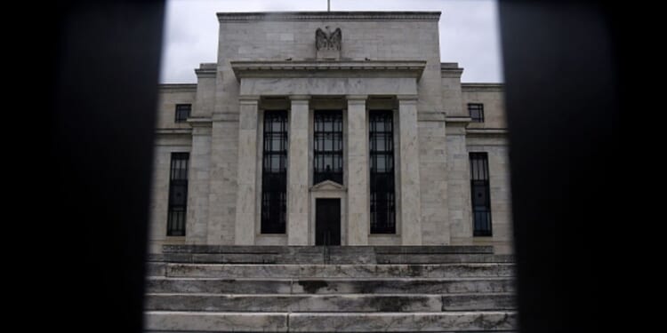 Dark clouds fill the sky behind the Federal Reserve Headquarters photographed from a fence on June 17, 2020.