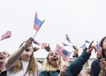 Parade attendees holding American Flags