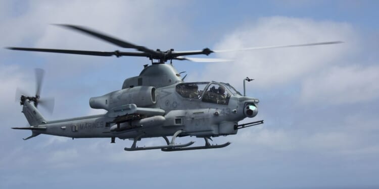 A U.S. Marine Corps AH-64 Apache helicopter flies through the sky on April 29, 2018.
