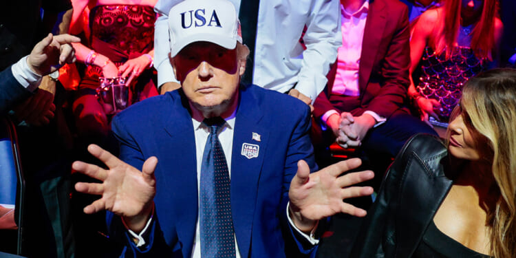 Donald Trump gestures to Melania Trump.