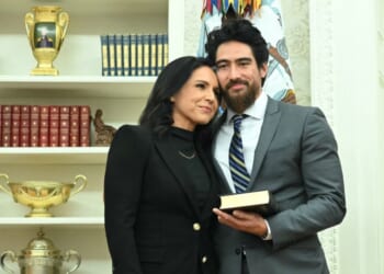 Tulsi Gabbard and her husband, Abraham Williams, hug before she is sworn in as Director of National Intelligence in the Oval Office of the White House in Washington, D.C., on Feb. 12, 2025.